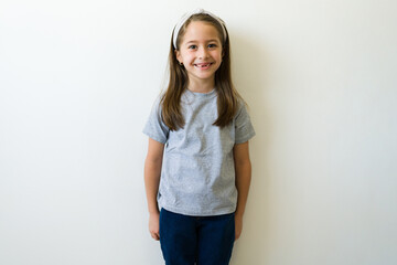 Fototapeta na wymiar Cheerful elementary girl with a casual mockup t-shirt