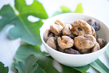 Dried figs with leaves isolated on white wood background
