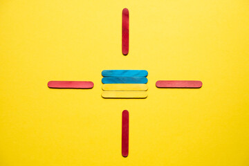 Flag of ukraine at gunpoint from red sticks top view. War in Ukraine