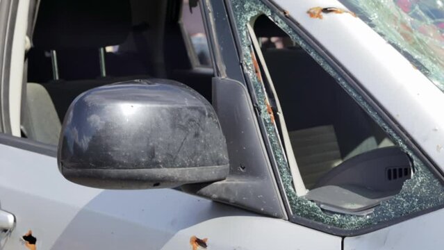 Bullet hole in a car door. Abandoned car with bullet holes. A destroyed vehicle in a war zone in Ukraine. Damaged civilian car. The car was damaged by shrapnel as a result of hostilities.