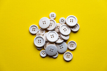 a lot of wooden buttons on a yellow background. Accessories for sewing