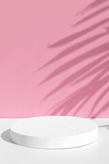 Minimal abstract pink and white background for eco cosmetic product presentation. Cylindrical white scene. Premium podium with a shadow of tropical palm leaves. Empty showcase.