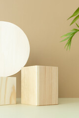 Wooden podiums, pedestals on a beige background with palm leaves. Showcases for the promotion of products, beauty, natural cosmetics. Abstract minimalistic elegant studio stage.
