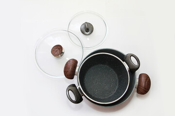 grey pots with teflon coating and glass lids on a white background