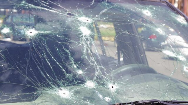 Bullet holes in the windshield of a car. Auto insurance. A car of civilians, with a broken windshield, damaged by shelling. Victims of the Russian full-scale invasion of the territory of Ukraine.