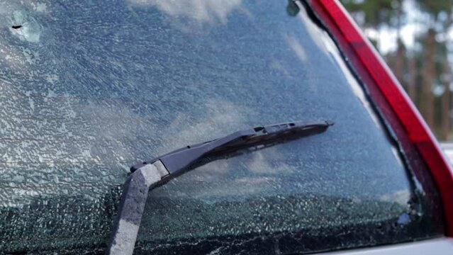 Bullet holes in the windshield of a car. Auto insurance. A car of civilians, with a broken windshield, damaged by shelling. Victims of the Russian full-scale invasion of the territory of Ukraine.