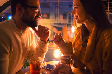 Young couple sitting in the romantic coffee shop at night