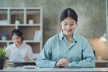 Charming asian businesswoman sitting working on laptop in office.