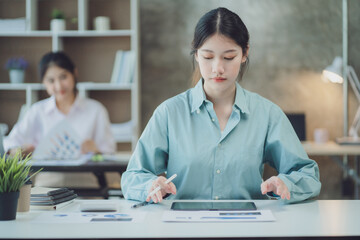 Charming asian businesswoman sitting working on laptop in office.
