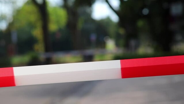 Red white barrier tape in pandemic lockdown marks crime scene restricted area as margin of safety to prohibit no trespassing in dangerous emergency and protection boundary for quarantine security stop