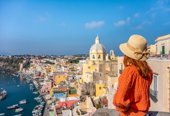 Beautiful young girl over panoramic view of Procida Island, Naples, Italy.