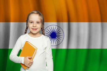 Beautiful small kid girl with book on flag of India background. Learn Hindi language concept.