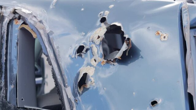 Car riddled with bullets. War of Russia against Ukraine. A car of civilians shot during the evacuation of women and children. Bullet holes and shell fragments. Cars destroyed by shell fragments.
