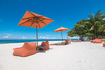 Beautiful square parasol and lounge chairs at a luxury white sand beachfront resort in Dumaluan...