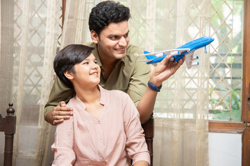 Happy indian father and daughter play with toy aeroplane, dream to become a pilot or air hostess....