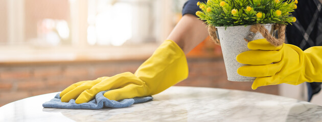 Cleaning hygiene, hand of maid, waitress woman wearing yellow protective gloves while cleaning ,...
