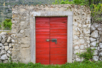 Stone wall with a red wooden door