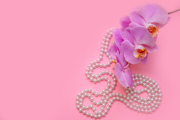 Pearl necklace and Purple orchid on pink background
