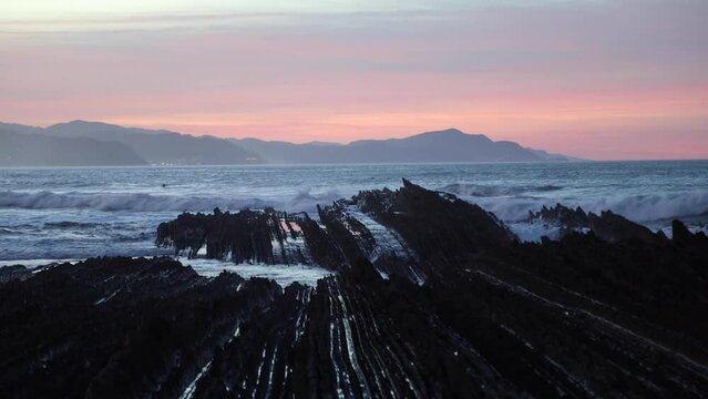 waves crashing on zumaia beach flysch at dusk