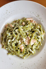 Background of vegetarian seafood pasta, spaghetti with salmon and squid close up. Top view, flat lay. Restaurant menu. Unhealthy food