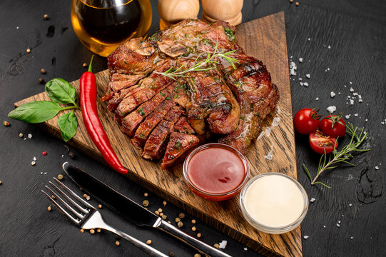 Fried medium rare marble steak with sauce on wooden background