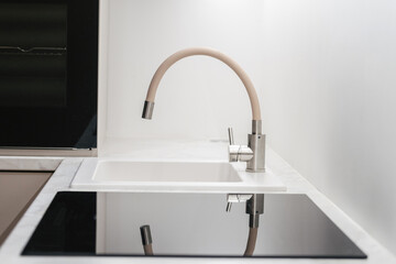 Kitchen faucet above a white empty sink