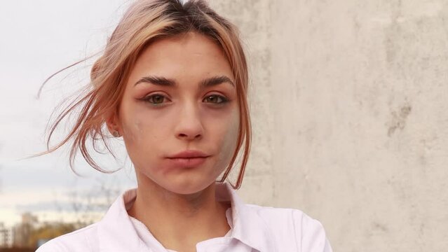 Dirty tired exhausted nurse with ash on face outside hospital infirmary after hard working day or surgery. Doctor woman dressed white medical gown, face mask have a rest due to stress
