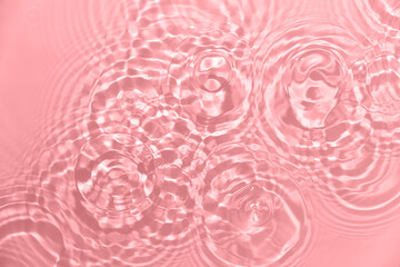 Rippled water background with circles and splashes. Pink, coral abstract texture
