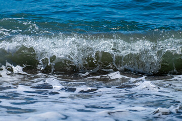 Ocean waves crashing on sandy beach. Sea waves breaking on shore.