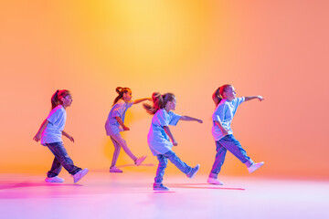 Hip-hop dance, street style. Happy children, little active girls in casual style clothes dancing...