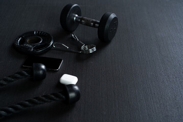 Naklejka na ściany i meble Fitness equipment on dark background, fitness equipment