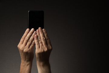 Hands holding smart phone, rear view