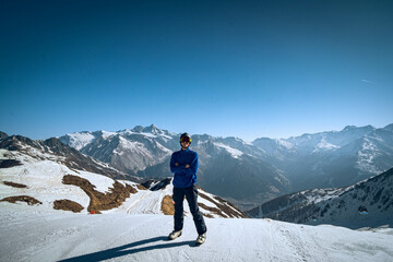 Fototapeta na wymiar skier on the top of mountain in a snowy mountain landscape and blue sky