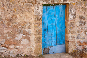 Aged wooden blue door and stone wall in Mallorca island. Spain