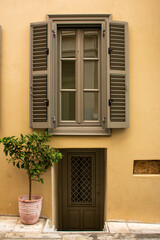 Facade of a house in Athens, with a subway door and a large window, Greece.