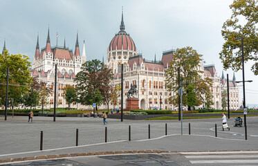 Obraz premium Budapest, Hungary - September 17, 2016: Building of the Hungarian Parliament city tram and cars in the city of Budapest.