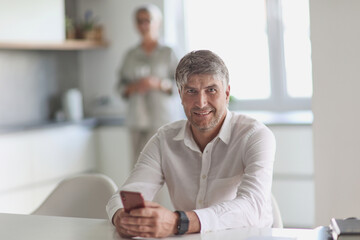 successful businessman holding a phone in his hand