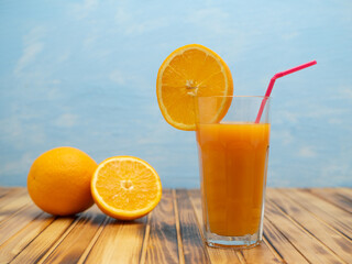 Orange juice in a glass with a slice of orange and an straw