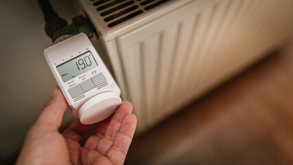 Zum Energiesparen wird elektronisches Thermostat an Heizung auf 19 Grad Raumtemperatur eingestellt