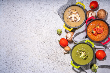 Autumn vegetable cream soups set. Three portion pots with various vegan hot vegetable cream soups – tomato, mushrooms, broccoli on white table copy space