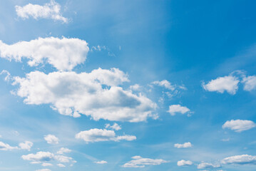 White clouds in the blue sky. White light cloudy heaven,good weather. Summer sky. Heaven and infinity. Curly clouds on a sunny day. Beautiful bright blue background.