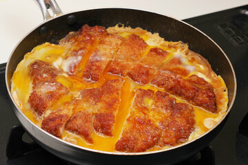 トンカツの卵とじを調理している