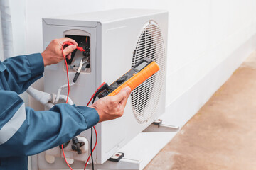 Repairman holding multimeter to check air conditioner system