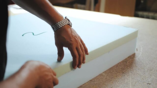 The factory for the manufacture of upholstered furniture. Gluing of foam rubber. The process of assembling and gluing upholstered furniture. Close-up. Unrecognizable 