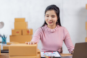 Portrait of young Asian woman working SME with a box at home the workplace.start-up small business owner, small business entrepreneur SME or freelance business online and delivery concept.