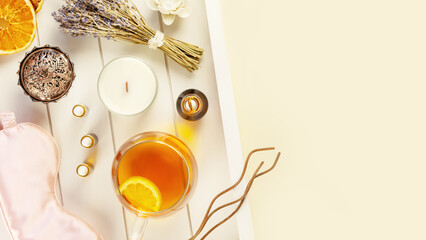 Relax at home. Cup of herbal tea, aroma candle, sticks, lavender flowers, dry oranges and natural oils on wooden tray with copy space. Insomnia or depression treatment. Self care and me time concept