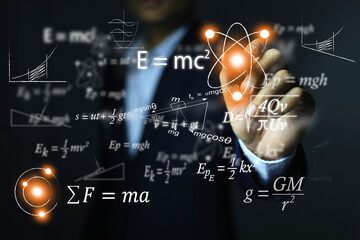 The man's hand points to the atomic equation of relativity by Albert Einstein. E equals m...