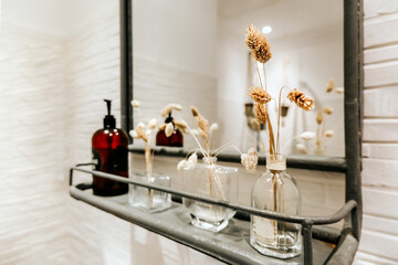 Home interior: shelf with bottles and toiletries next to the mirror in the bathroom