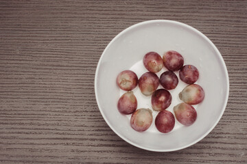 Obraz premium plate with a serving of fresh red globe grapes, a healthy snack for pre-workout meals. Natural low-fat diet with antioxidants and polyphenols