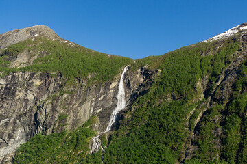 Fototapeta na wymiar Geiranger Fjord in Norway with waterfalls cascading down the high mountains.
